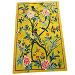 Vibrant Golden Garden Hand Tufted Area Rug measuring 5' x 8'. This wool rug features an intricate floral design with colorful birds perched on branches, perfect for enhancing dining room decor. The lively floral pattern makes it an ideal choice for living room area rugs, adding a touch of elegance and warmth.