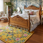 Golden Garden hand tufted rug in bedroom under carved oak bed, golden yellow with birds on branches and pink blooms