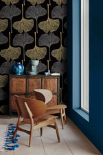Golden Gingko Grove Wallpaper in gold and grey leaves beside a red cabinet and wood chairs