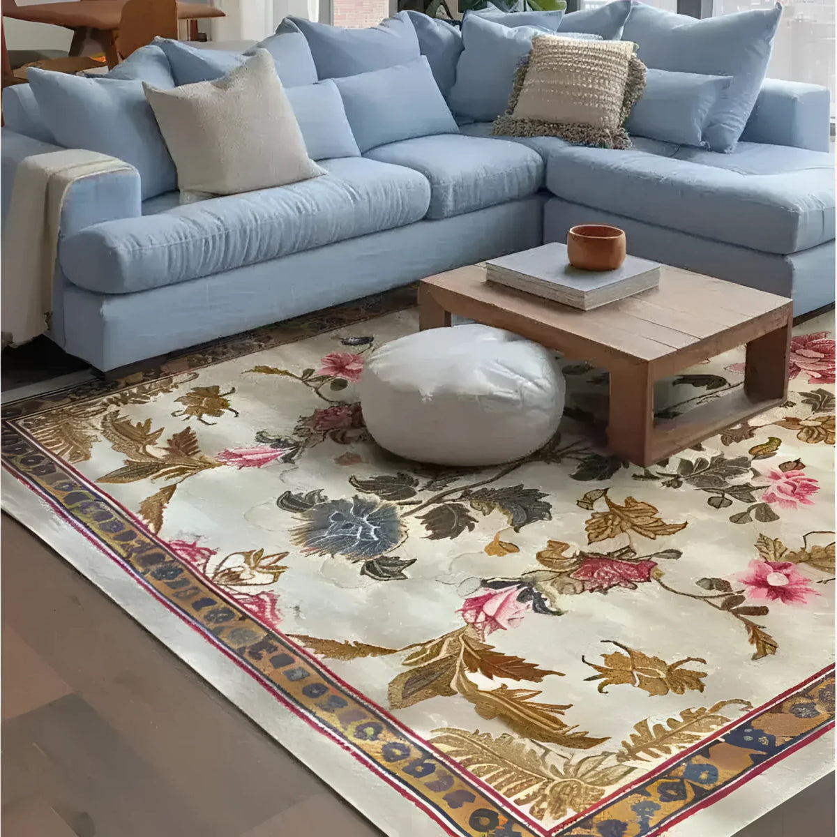 A beautifully designed Golden Glory Square Hand Tufted Wool Rug graces the floor of a cozy living room. The square area rug features an elegant floral pattern with vibrant colors, making it a perfect choice for bedrooms or large living rooms. The wool rug complements the light blue sectional sofa, creating a warm and inviting atmosphere, ideal for area rugs in living rooms.