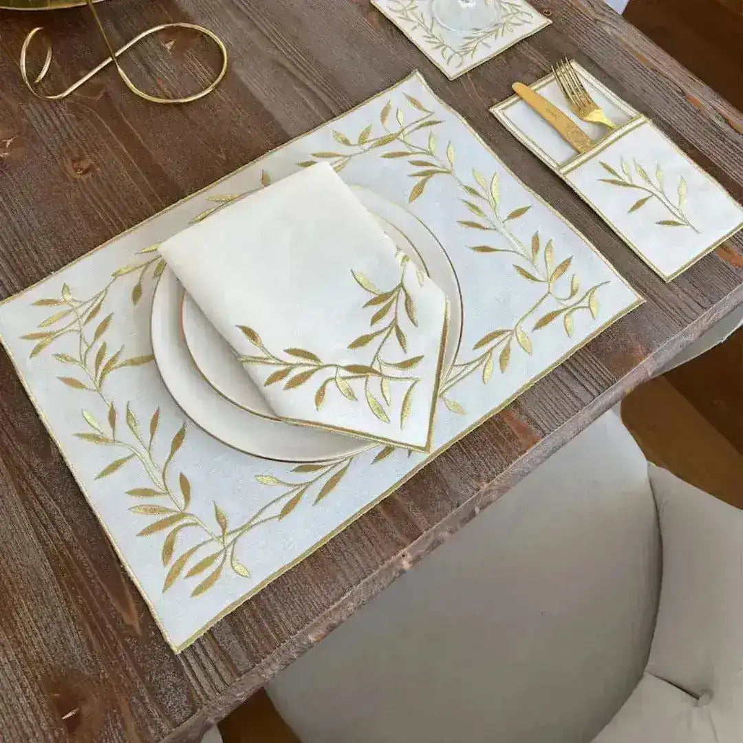 Golden Leaf Elegance placemat overhead view with white linen gold embroidered leaf border and matching napkin on plate