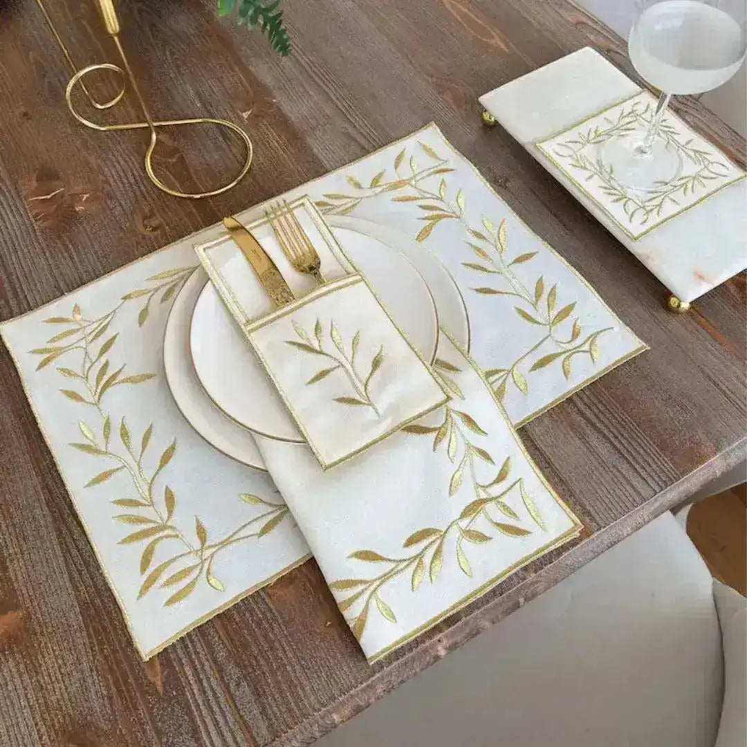 white Golden Leaf Elegance placemats with gold embroidered leaf branches and gold trim on rustic dark wood table