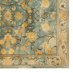 Top view of a Golden Petals Hand Tufted Wool Rug, featuring an intricate vintage floral design with golden petals on a soft blue background. This 8x10 area rug is perfect for adding a touch of elegance to your living room decor.