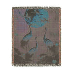 Golden Serenity woven blanket corner folded back showing large orange and pink cosmos flowers on dark navy, grey backing visible
