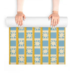 Hands unrolling Golden Solstice yoga mat revealing blue squares, cream stars and gold stripes