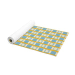 Partly rolled Golden Solstice yoga mat with blue and cream star-check pattern and gold stripes