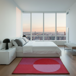 Modern bedroom with a large bed, pink rug, and cityscape view.