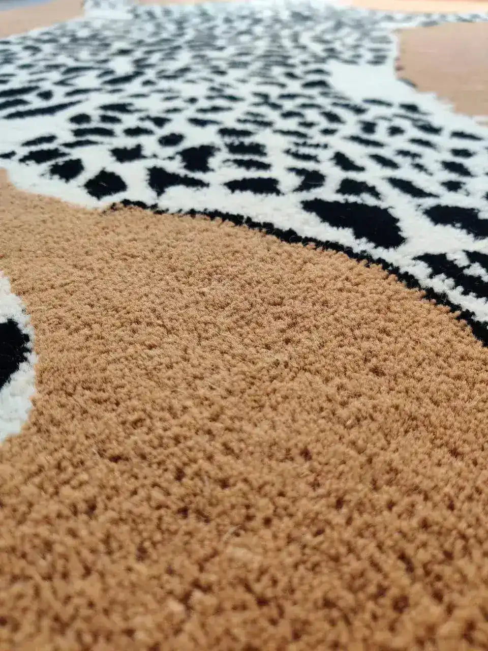 Close-up view of the Goldy Leopard Hand Tufted Wool Rug, showcasing its intricate leopard pattern and plush texture. This area rug, perfect for a living room, highlights the luxurious feel of wool rugs, ideal for large living room spaces.