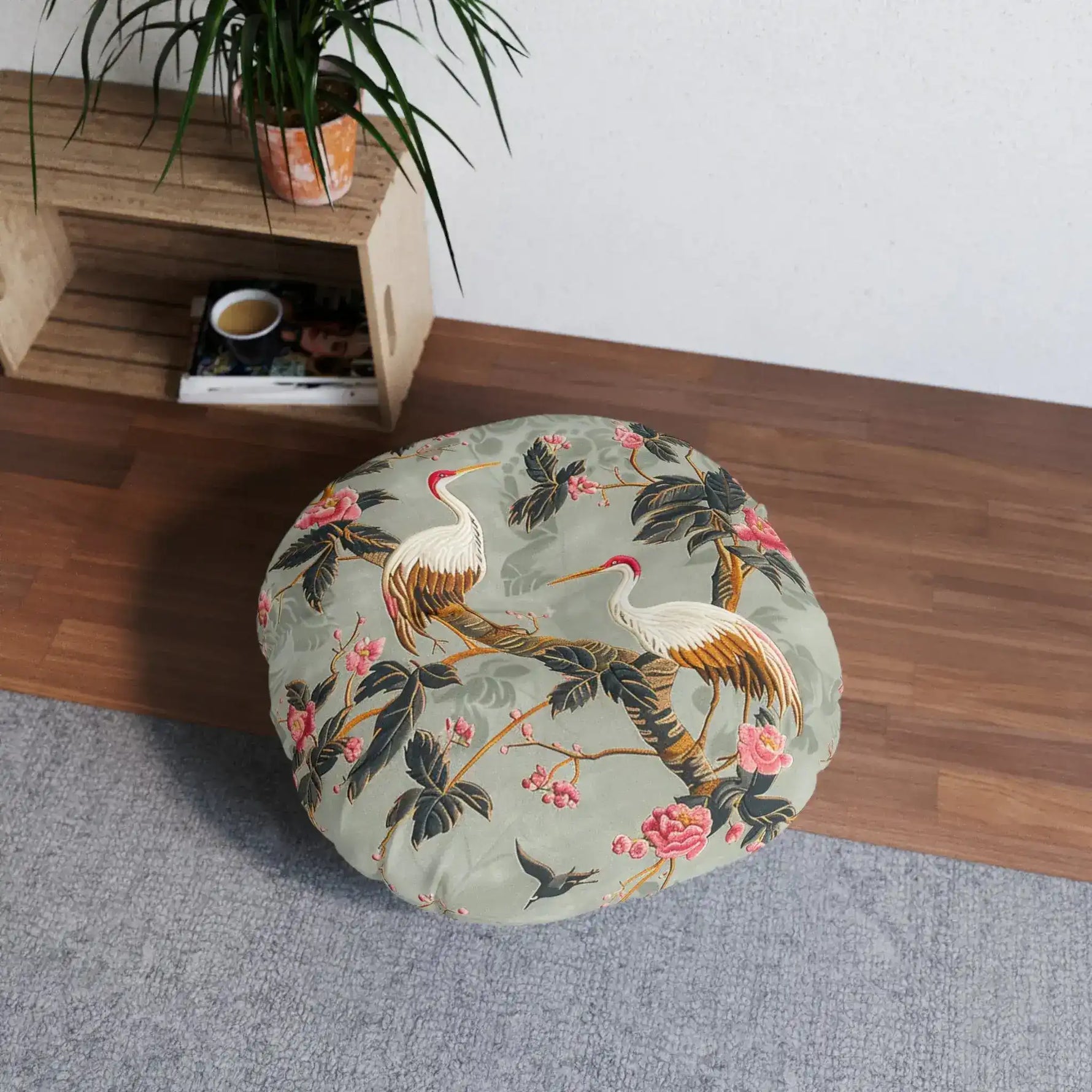 Graceful Crane and Blossom Pattern Floor Pillow in room setting beside wooden shelf with plant, on wood floor and grey rug