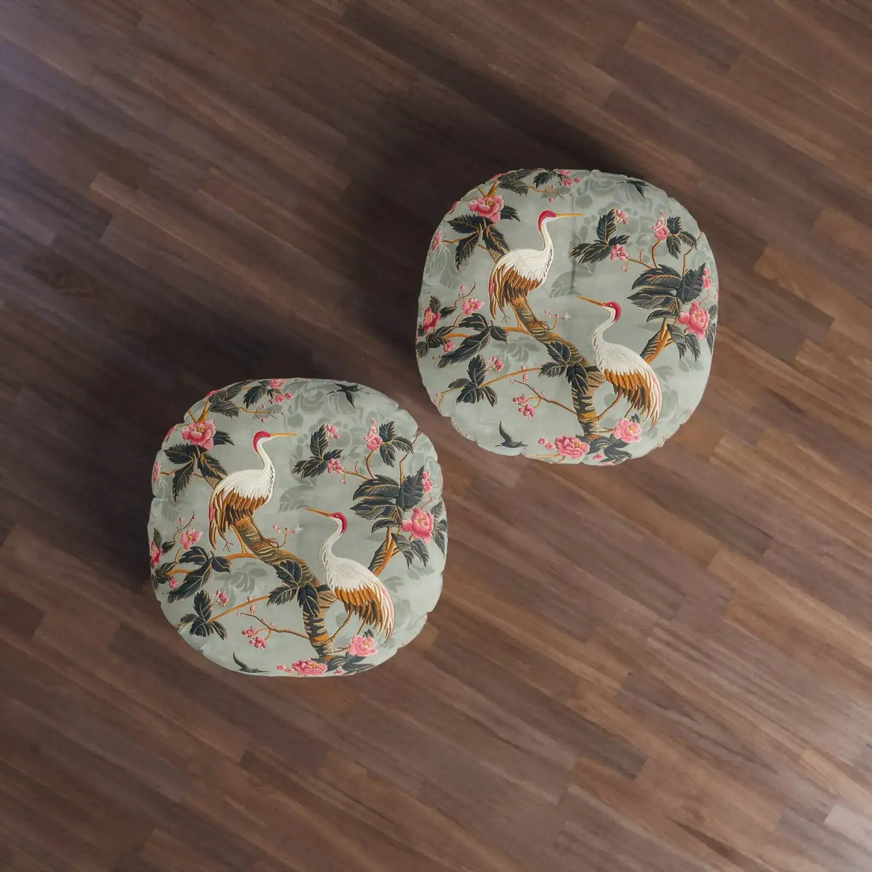 Two Graceful Crane and Blossom Pattern Floor Pillows overhead view on dark wood floor, sage-green crane-blossom print