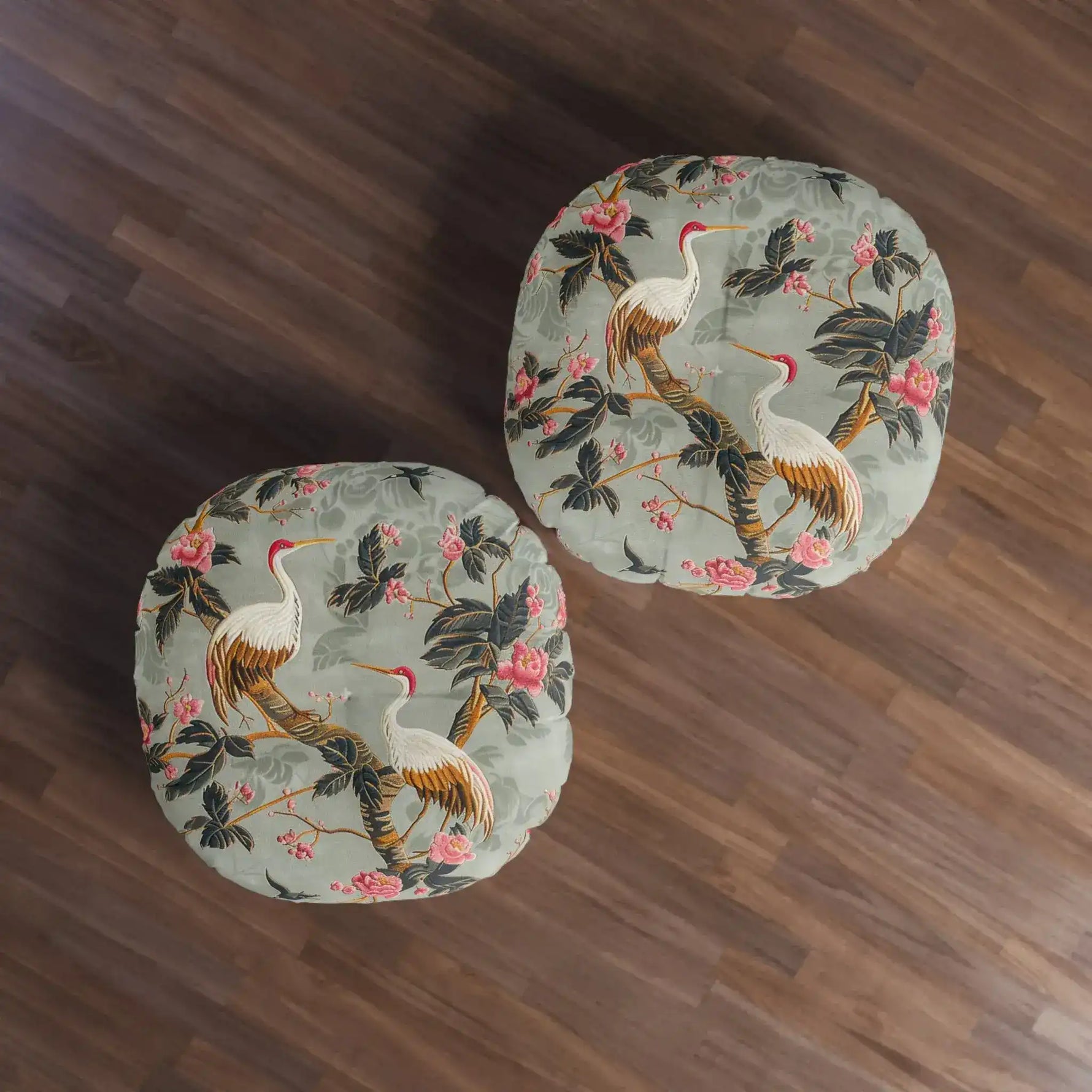 Two Graceful Crane and Blossom Pattern Floor Pillows viewed from above on dark hardwood floor, sage-green print
