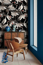 Graceful Crane Haven Wallpaper of dense cranes beside a red cabinet and wood chairs