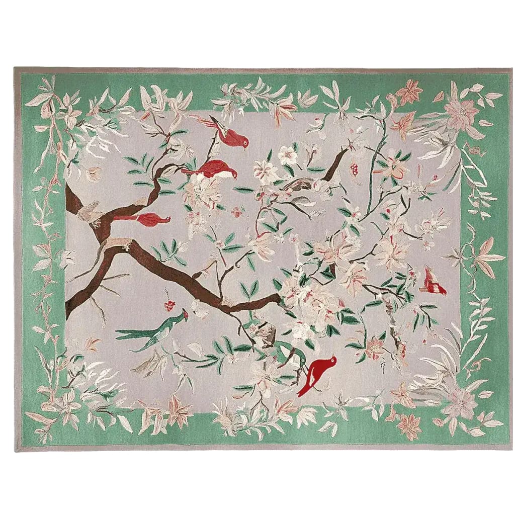 Graceful Eden Echo hand-tufted area rug featuring a vibrant floral and bird design. This wool rug, perfect for large living rooms, showcases intricate details with a green border and multicolored accents, ideal for adding elegance to any area rug setting.