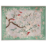 Graceful Eden Echo hand-tufted area rug featuring a vibrant floral and bird design. This wool rug, perfect for large living rooms, showcases intricate details with a green border and multicolored accents, ideal for adding elegance to any area rug setting.