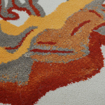 Close-up of a colorful patterned rug with red, orange, yellow, and gray colors.