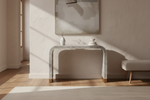 Gray and white stripe waterfall bone inlay console table with brass feet in a sunlit room.