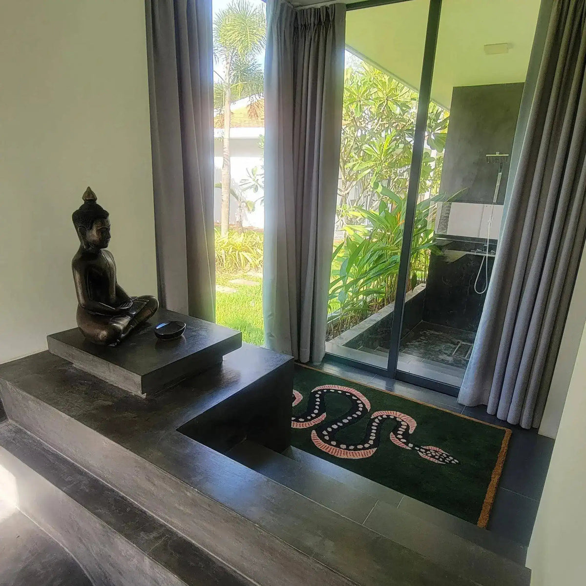 A beautifully designed Green and Black Snake Hand Tufted Wool Area Rug placed elegantly in a serene setting. This vintage rug adds an artistic touch, perfect for a dining room or as a dining table rug. Its intricate snake motif makes it a standout piece among living room rugs 8x10, showcasing the luxury of a wool rug in a peaceful living room setting with natural light streaming in from a large window.