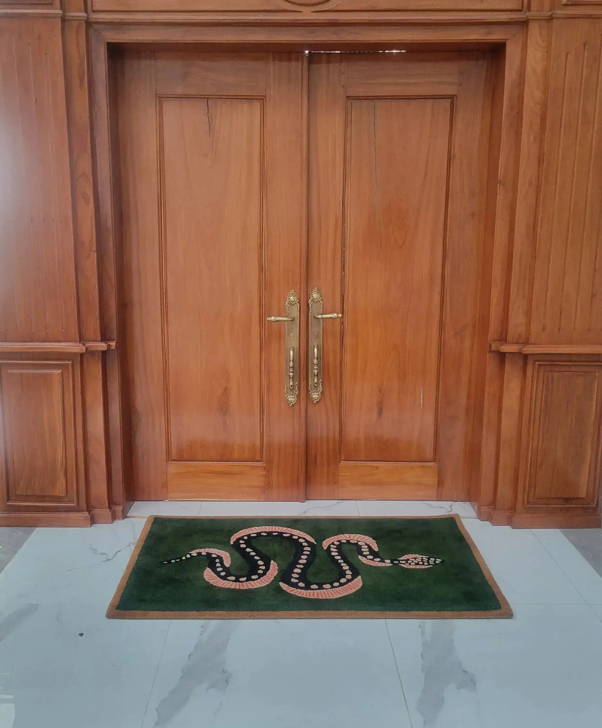 Elegant Green and Black Snake Hand Tufted Wool Area Rug placed in front of wooden double doors. This vintage rug adds a unique touch to your dining room or living space, perfect as a dining table rug or living room rug 8x10. The wool rug features a bold snake design on a lush green background, ideal for enhancing the style of any living room.