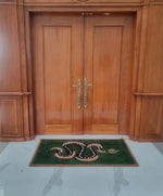 Elegant Green and Black Snake Hand Tufted Wool Area Rug placed in front of wooden double doors. This vintage rug adds a unique touch to your dining room or living space, perfect as a dining table rug or living room rug 8x10. The wool rug features a bold snake design on a lush green background, ideal for enhancing the style of any living room.