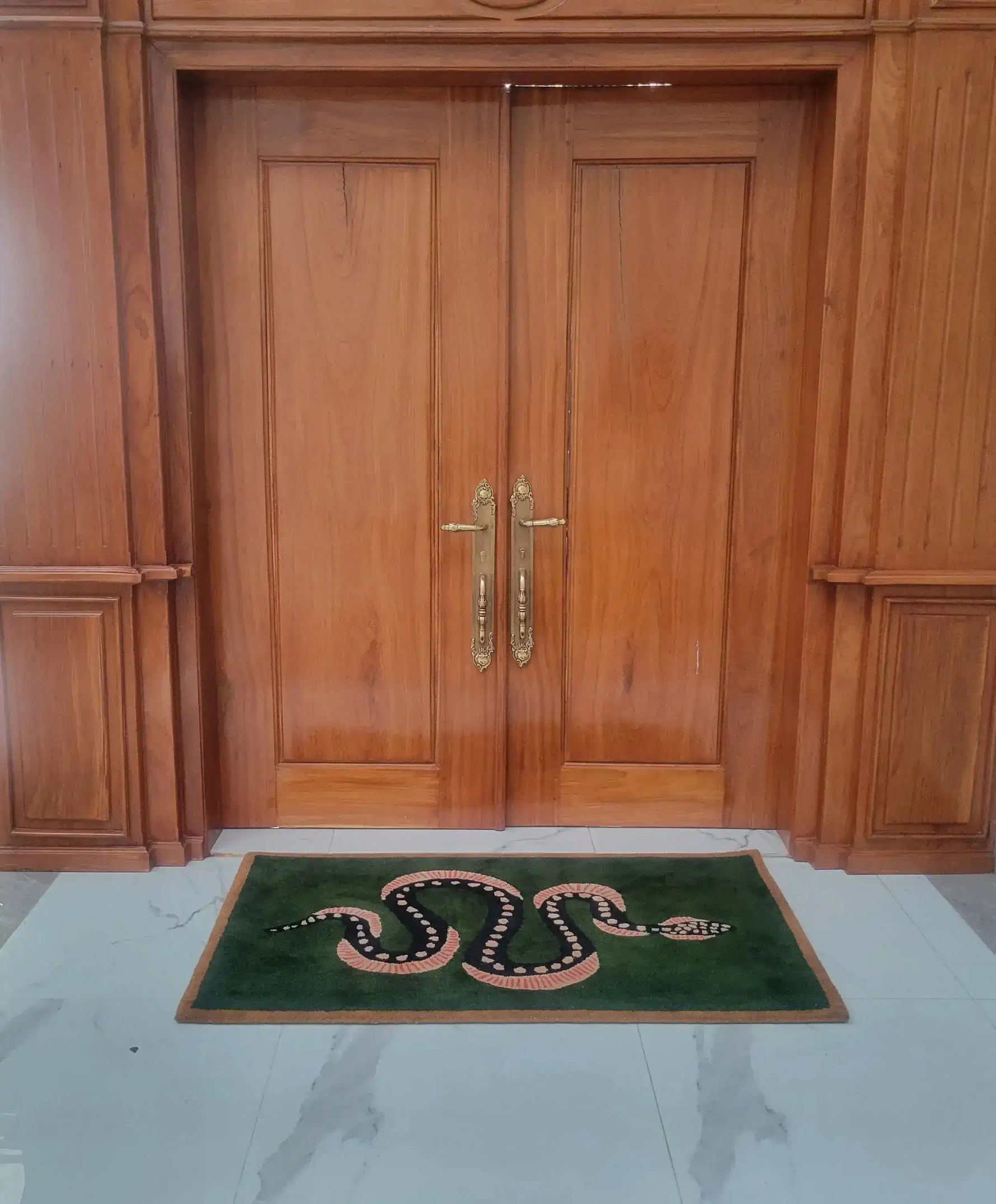 Elegant Green and Black Snake Hand Tufted Wool Area Rug placed in front of wooden double doors. This vintage rug adds a unique touch to your dining room or living space, perfect as a dining table rug or living room rug 8x10. The wool rug features a bold snake design on a lush green background, ideal for enhancing the style of any living room.
