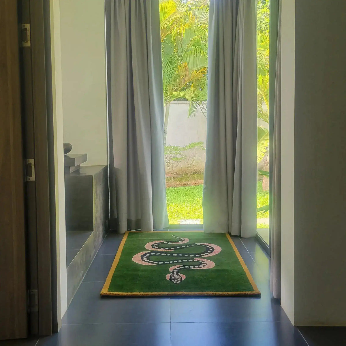 A stylish hand-tufted wool area rug featuring a green and black snake design. Perfect for adding a vintage touch to dining rooms or as a striking living room rug in an 8x10 size. Ideal for placing under a dining table, this wool rug enhances any interior with its bold pattern and luxurious texture.