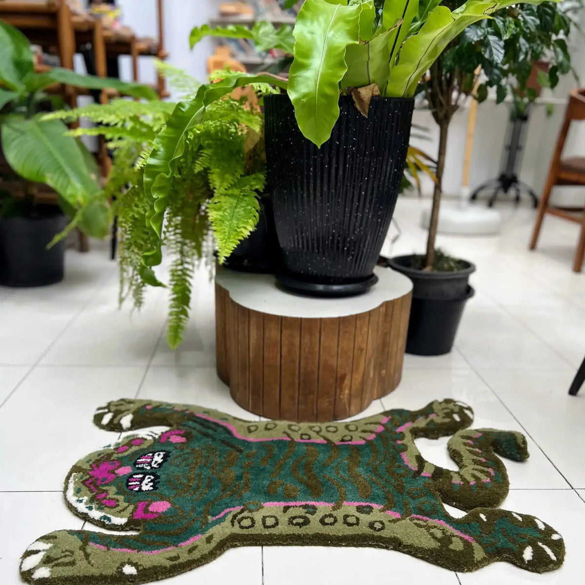 A vibrant Green Asian Tiger Wool Rug with an abstract design, perfect for adding a vintage touch to any dining room or office. This area rug, resembling a stylized tiger, is surrounded by lush greenery, making it an ideal formal dining room rug or dining room carpet.