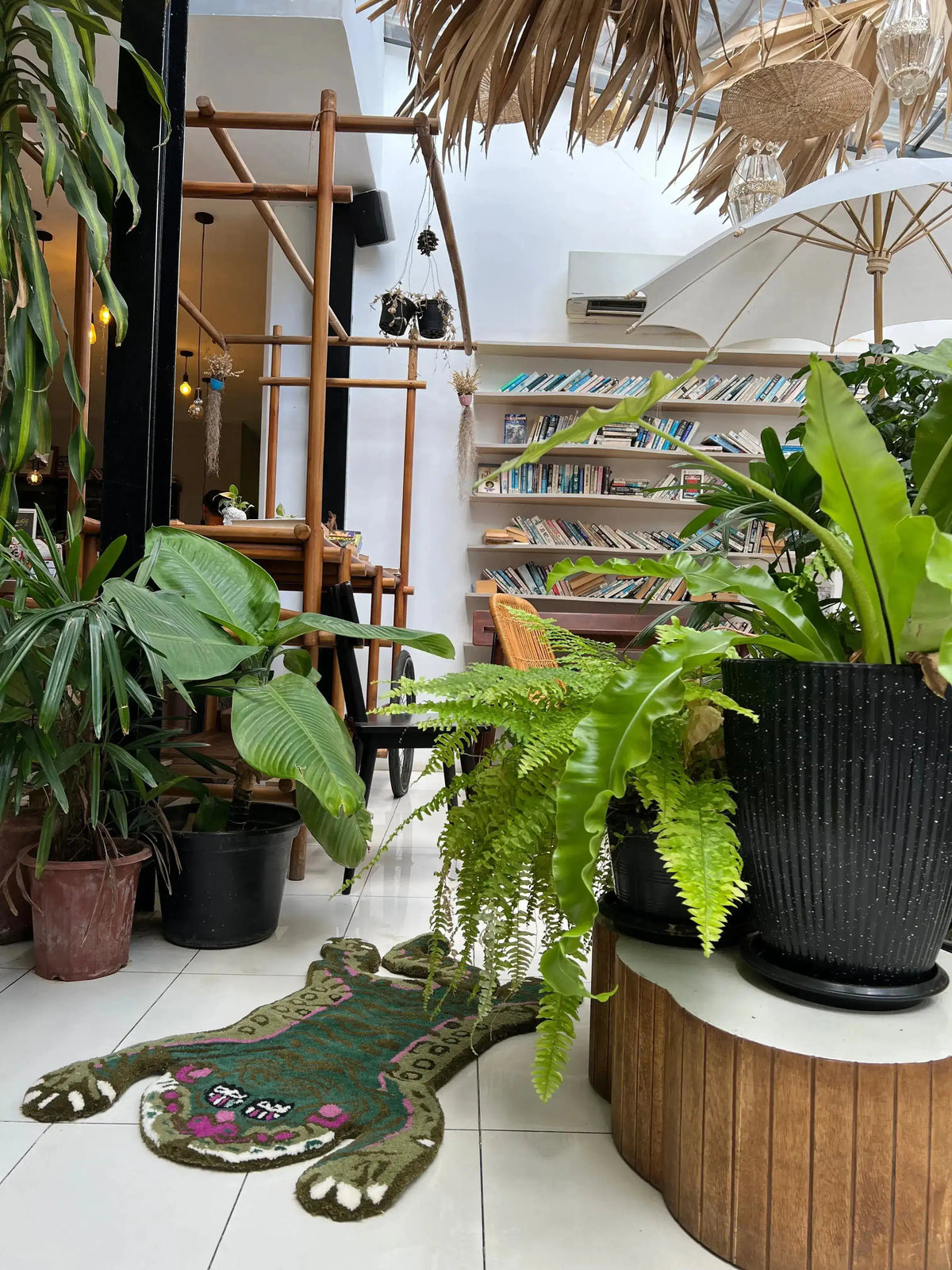 Stylish Green Asian Tiger Wool Rug in a vibrant indoor setting, surrounded by lush green plants. This vintage area rug adds a unique touch to any dining room or office, acting as a perfect formal dining room rug or dining room carpet.