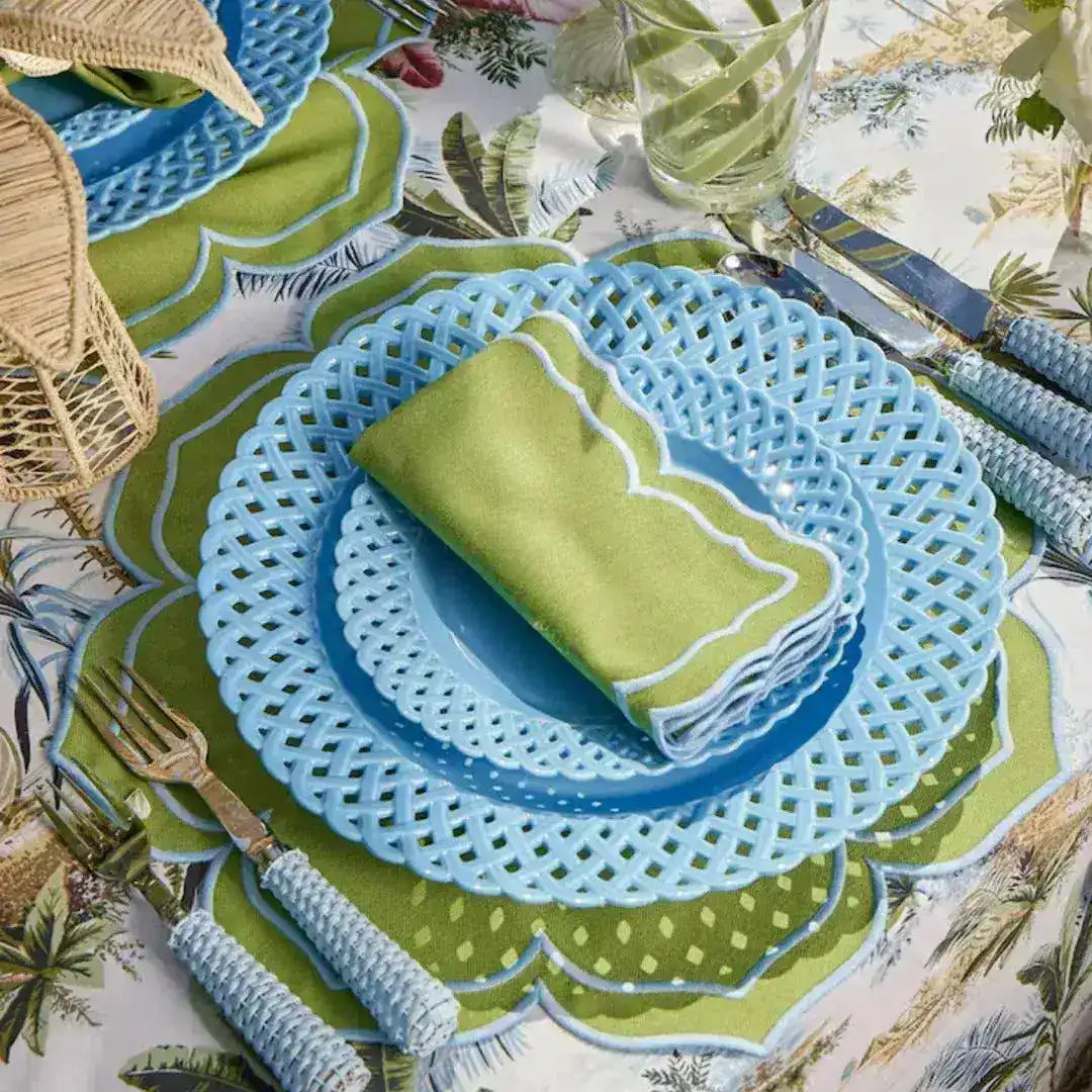 green essence placemat scalloped green white close-up with blue lattice plates green napkin white border on palm tablecloth