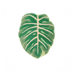 A vibrant green leaf-shaped decorative bathroom mat made from soft cotton, ideal as a runner rug in the kitchen or hallway. The intricate design resembles a tropical leaf, adding a refreshing touch to any bathroom decor.