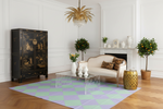 Living room with a black cabinet, checker rug, white sofa, and decorative elements.