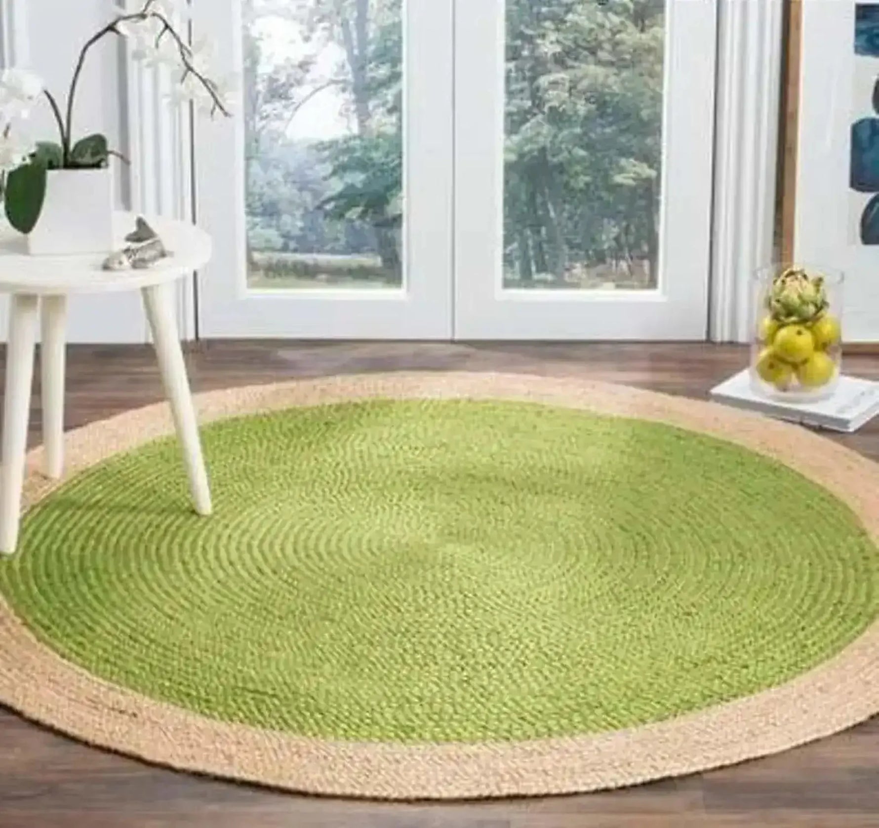 A beautifully crafted green round jute rug, perfect for adding a natural touch to your dining room or bedroom. The area rug features a vibrant green center with a natural jute border, making it an ideal dining table rug or a cozy addition to dining room carpets. Placed on a wooden floor, this round rug complements the bright and airy decor.