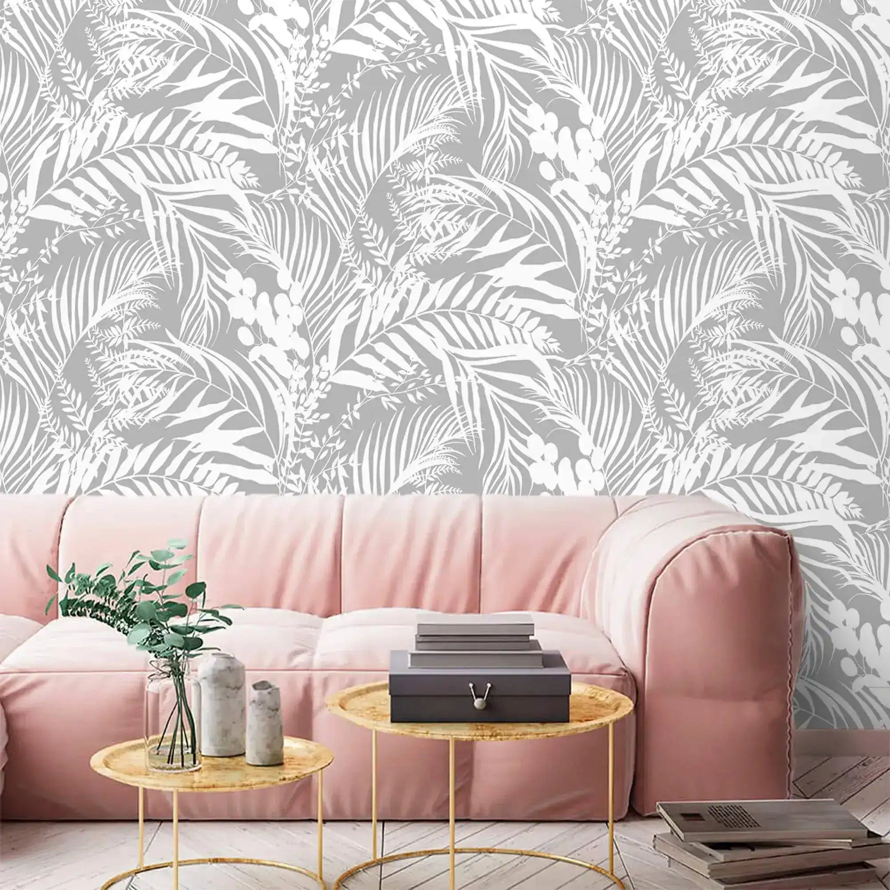 Grey Tropical Foliage Wallpaper of white leaves on grey behind a soft pink sofa