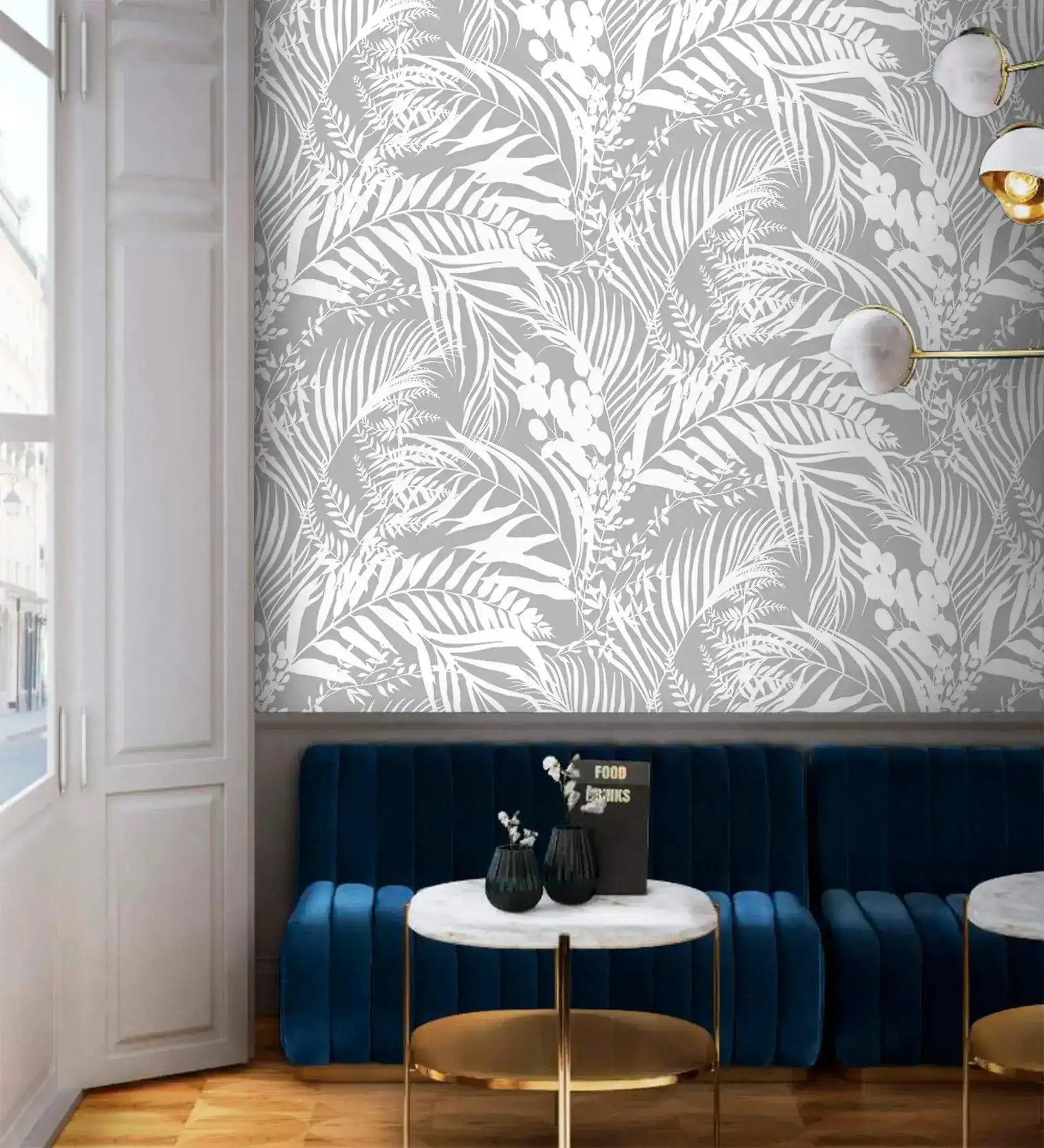 Grey Tropical Foliage Wallpaper of white palm fronds behind a navy velvet banquette