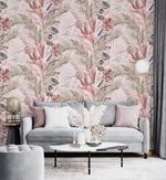 Grey velvet sofa and marble table against pink tropic breeze wallpaper with blush fronds