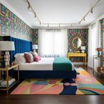 Colorful bedroom with geometric patterns on walls and rug, blue bed, and yellow side table.
