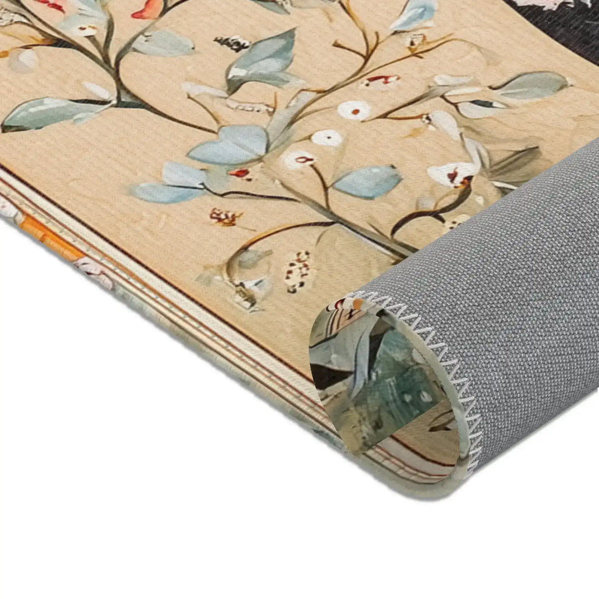 Hand-Painted Floral Rug - Rolled corner detail with blue-grey leaf print on cream ground, grey non-slip backing with decorative edge stitch