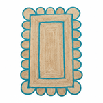 Rectangular jute rug with blue scalloped edge on a white background