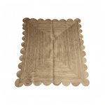Beige woven jute rug with scalloped edge on a white background