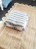 A beautifully handmade white scalloped jute rug displayed in a cozy living room setting. The area rug features intricate weaving patterns and a natural color palette, making it an ideal choice for both dining room and living room decor. Its elegant scalloped edges add a touch of sophistication, perfect for enhancing any living room area.