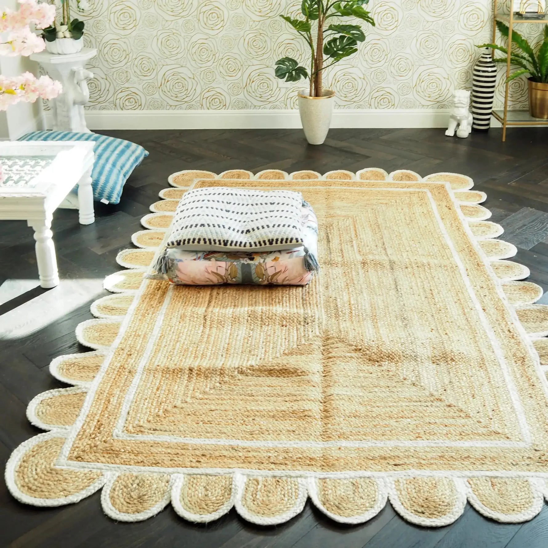 Stylish handmade white scalloped jute area rug placed in a bright living room. The rug enhances the dark wooden floor, adding warmth and texture. Perfect for dining rooms or as a centerpiece among rugs for living rooms.