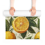 Hands unrolling a yoga mat to reveal a large sliced-lemon and foliage print in vivid yellow and green