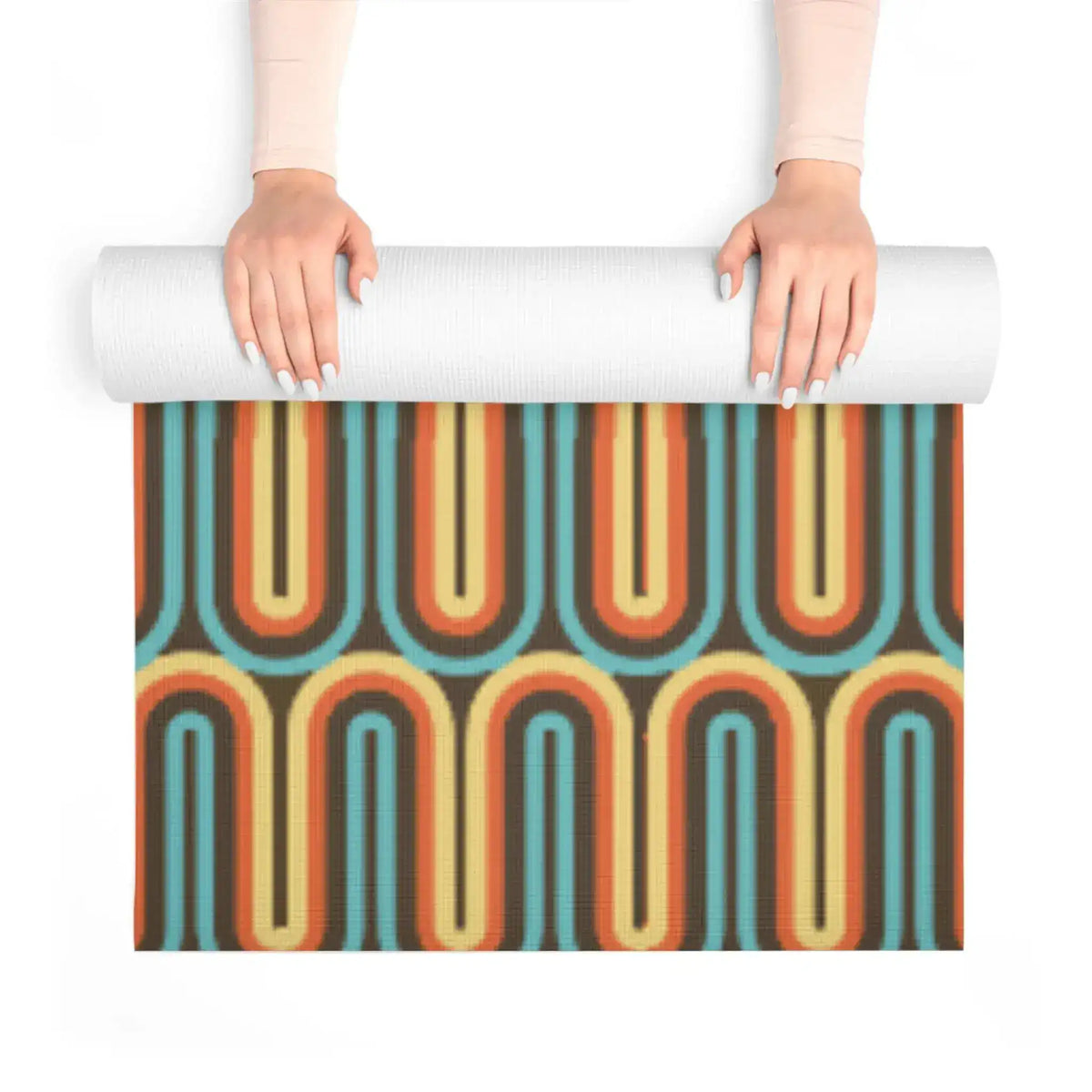 Hands unrolling a yoga mat with retro looping lines in teal, orange and cream on brown