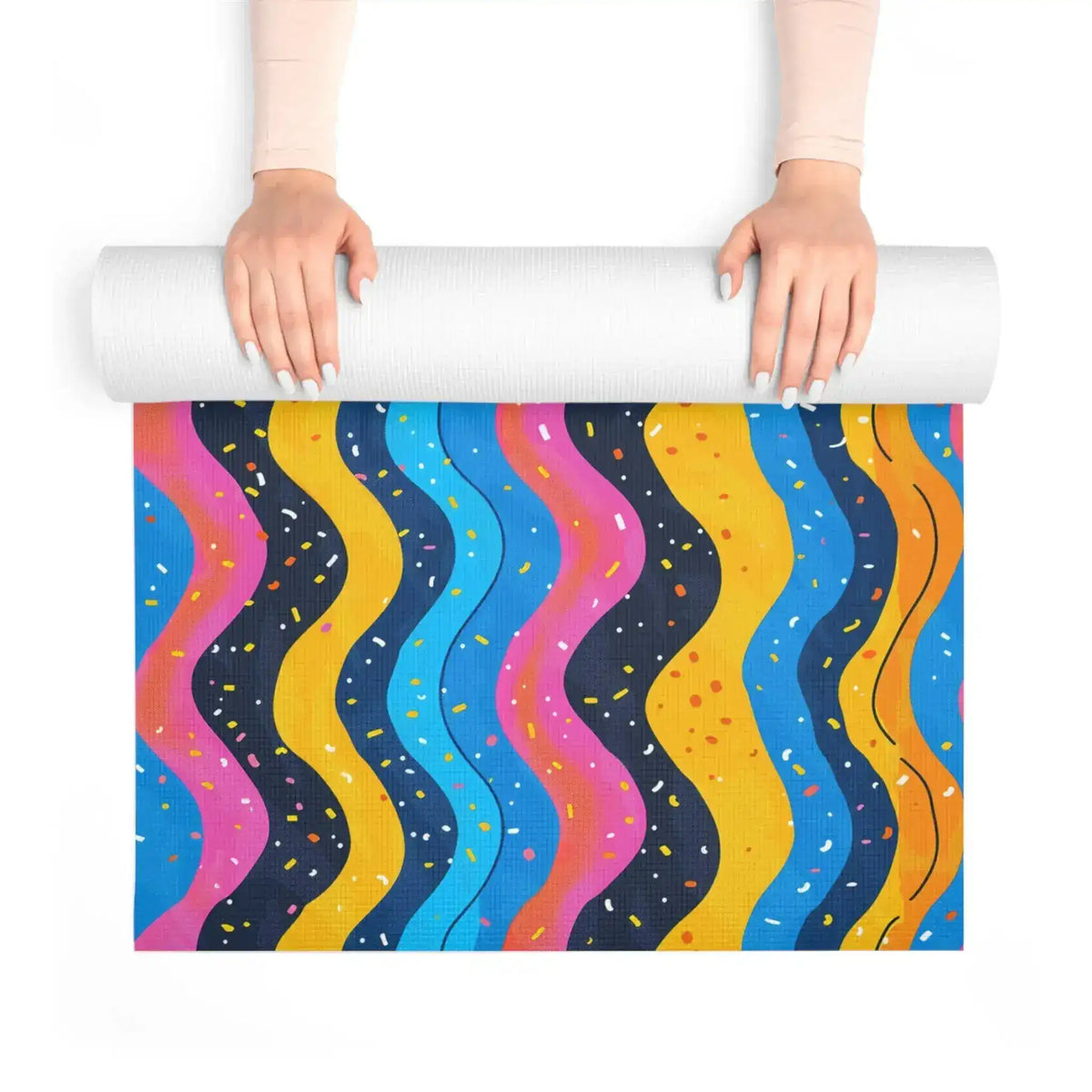 Hands unrolling Carnival Currents yoga mat revealing wavy confetti-dotted stripes in bright colors