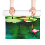 Hands unrolling foam yoga mat revealing pink lotus and green lily pond print