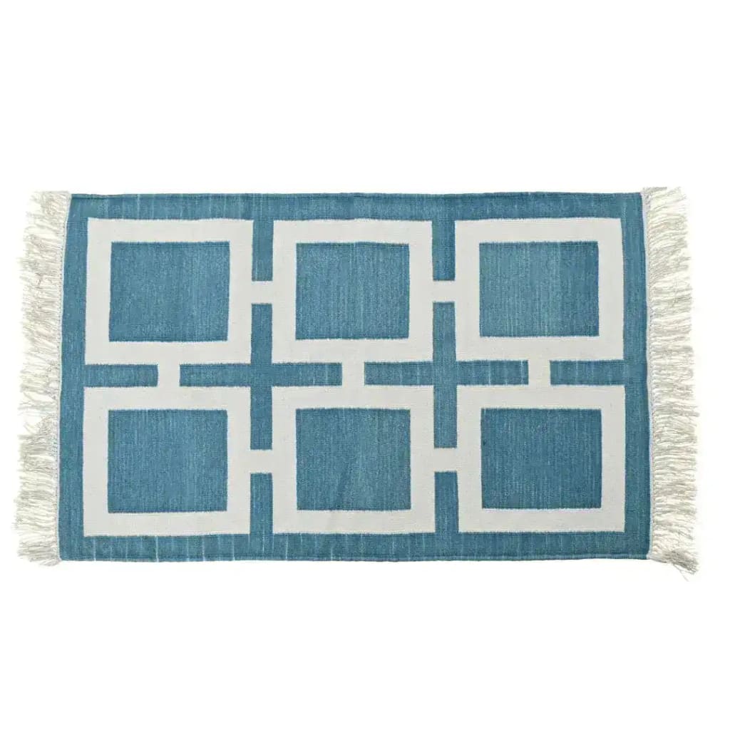 Handwoven blue and white geometric cotton area rug with fringe detailing, perfect for a boho living room. This large area rug features a modern design, ideal for those seeking stylish and durable large area rugs for their living room.