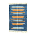 Handwoven Earth and Ocean Cotton Rug with Fringes, showcasing a boho design in blue and orange stripes. Perfect as a large area rug under a dining table, this cotton rug adds a natural touch to any dining room.
