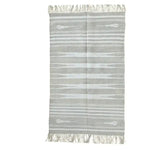 Handwoven gray and white stripe cotton area rug with fringes, perfect for a living room. This large boho rug, sized 8x10, features a stylish pattern ideal for modern interiors.