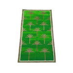 A vibrant green handwoven cotton rug featuring an elegant palm tree pattern, perfect for enhancing the boho style of your dining room or living room. This area rug, measuring 8x10, adds a touch of nature-inspired charm under a dining table or as a standout piece in a living space.