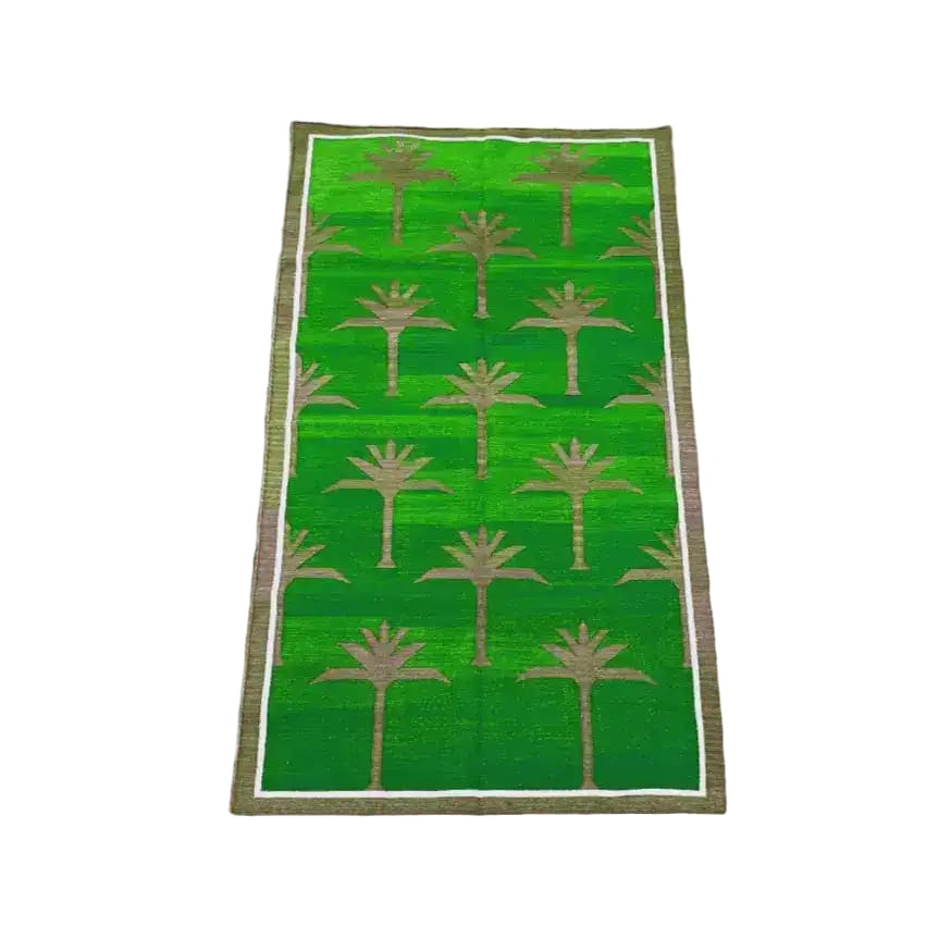 A vibrant green handwoven cotton rug featuring an elegant palm tree pattern, perfect for enhancing the boho style of your dining room or living room. This area rug, measuring 8x10, adds a touch of nature-inspired charm under a dining table or as a standout piece in a living space.