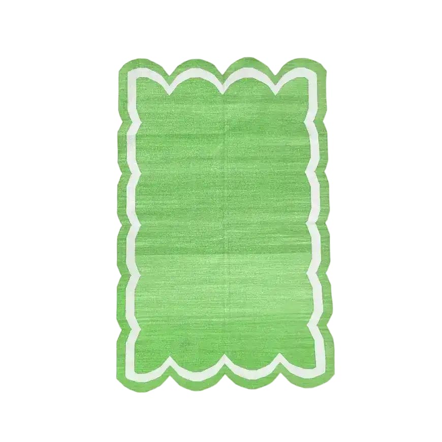 Handwoven green and white scallop cotton area rug, perfect for adding a touch of boho style to your living room. This large area rug features a vibrant green with a unique scalloped edge, ideal for those seeking stylish rugs for living room spaces.